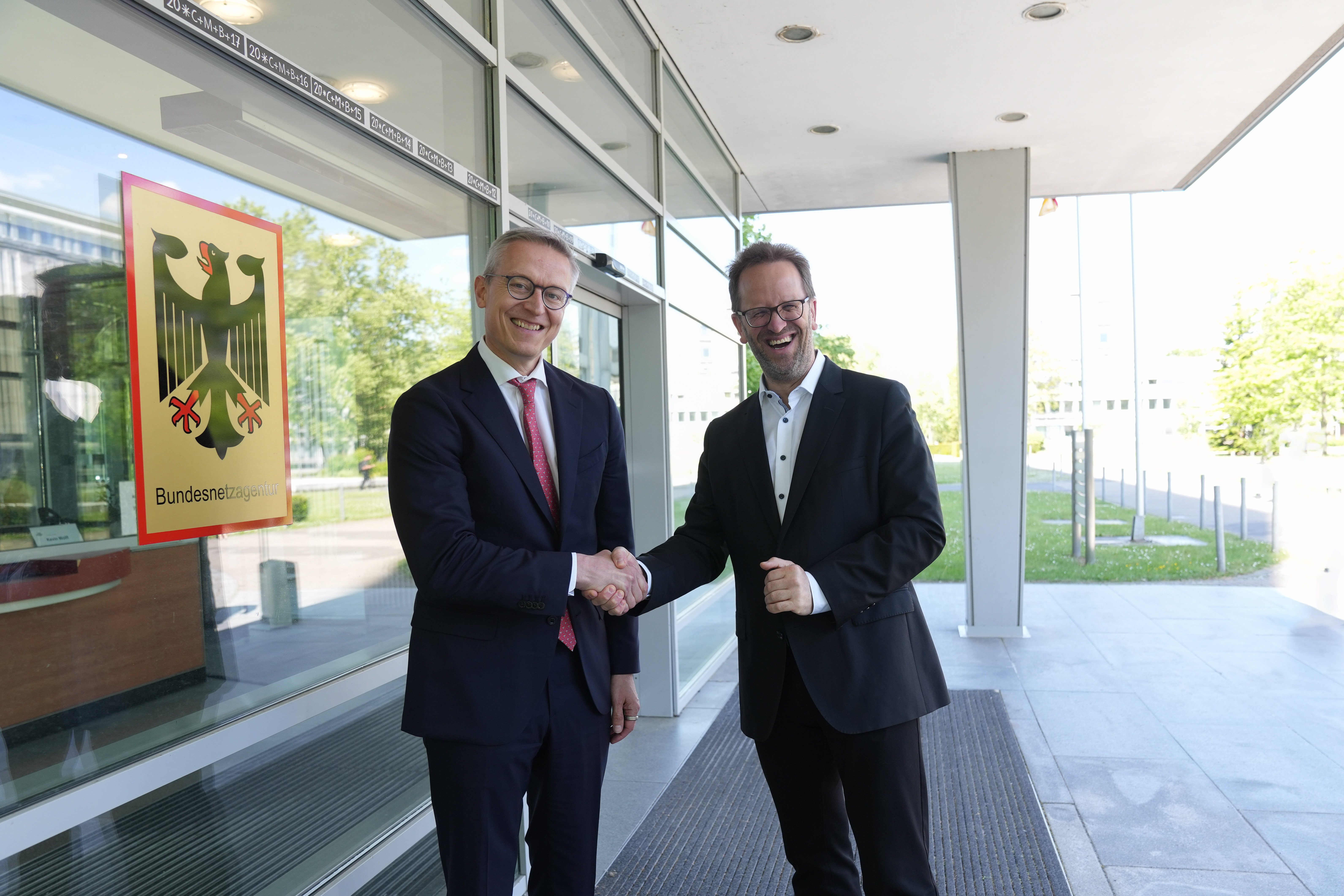 Bundesdigitalminister Wildberger und Bundesnetzagentur-Präsident Müller schütteln die Hände.