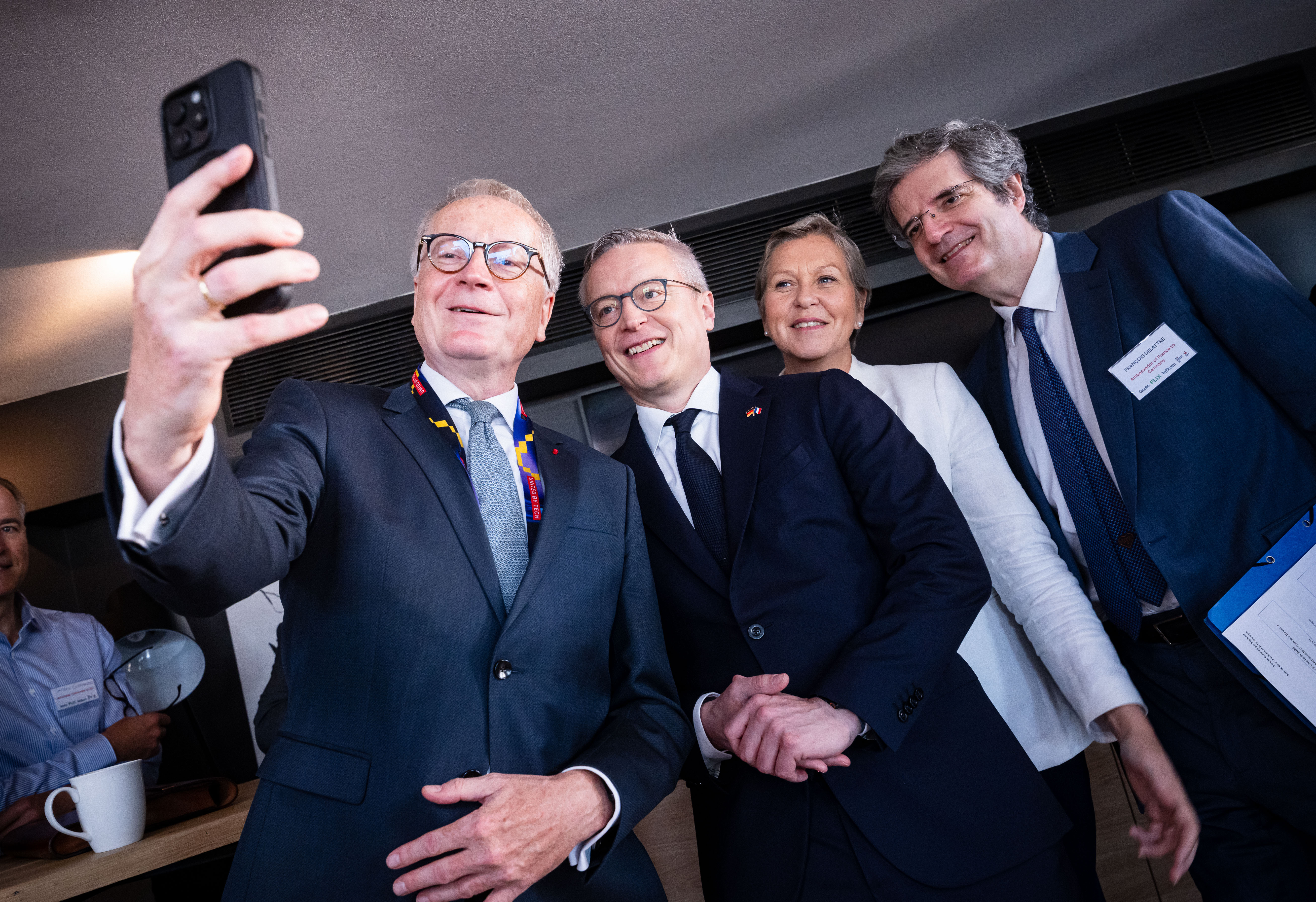 Vier Personen in Business-Kleidung machen ein Selfie.