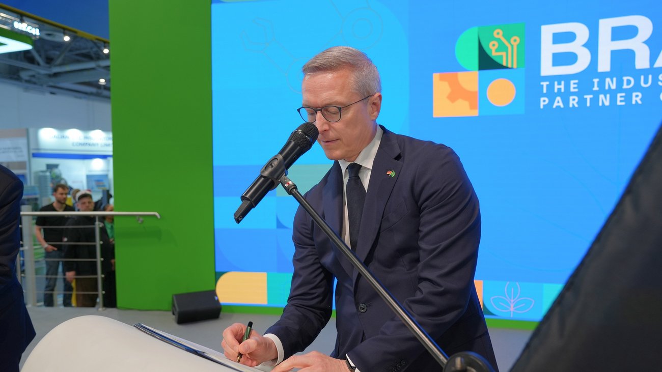 Dr. Wildberger beim unterzeichnen eines gemeinsamen Abkommens.