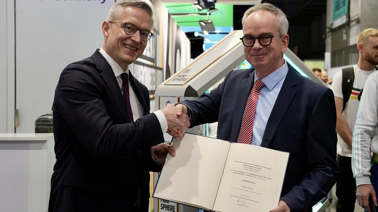 Das Bild zeigt den deutschen Bundesminister für Digitales und Staatsmodernisierung, Dr. Karsten Wildberger (links), und Prof. Dr. Hans Dieter Schotten (rechts) am Messestand der „6G Platform Germany“ auf dem Mobile World Congress (MWC) 2026 in Barcelona.