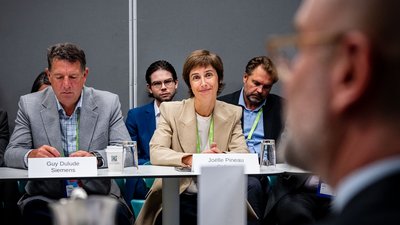 Joelle Pineau sitzt an einem Konferenztisch und blickt in die Kamera.