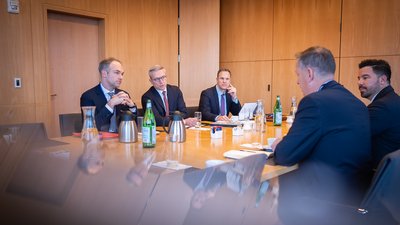 Minister Wildberger in einer Besprechung mit Joseph Larson, Lauren Oliphant und weiteren Personen