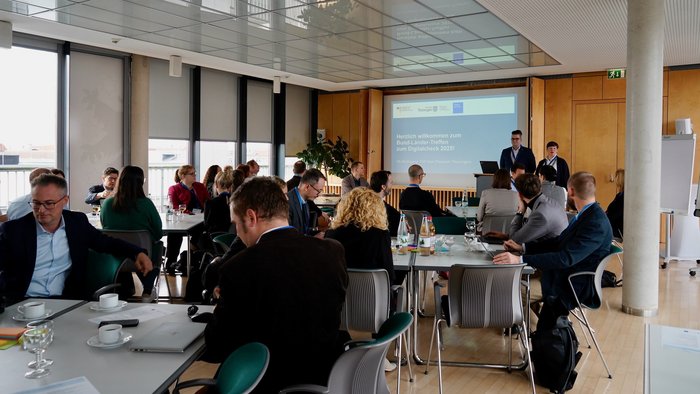 Philipp Gerth (Thüringer Ministerium für Digitales und Infrastruktur) und Katrin Lüt-kemöller Shaw (BMDS) begrüßen die Teilnehmerinnen und Teilnehmer zum Bund-Länder-Treffen.