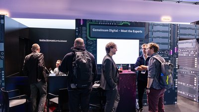 Situation an einem Counter am Messestand, im Hintergrund liest man "Mobiles Bürgeramt Steglitz-Zehlendorf". 