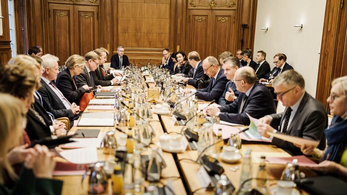 Blick auf einen großen Tisch, an dem die Mitglieder der Bundesregierung sitzen. Karsten Wildberger sitzt an der Kopfseite des Tisches.