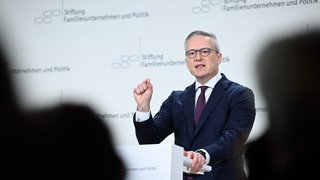 Karsten Wildberger steht an einem Rednerpult und hält eine Rede.