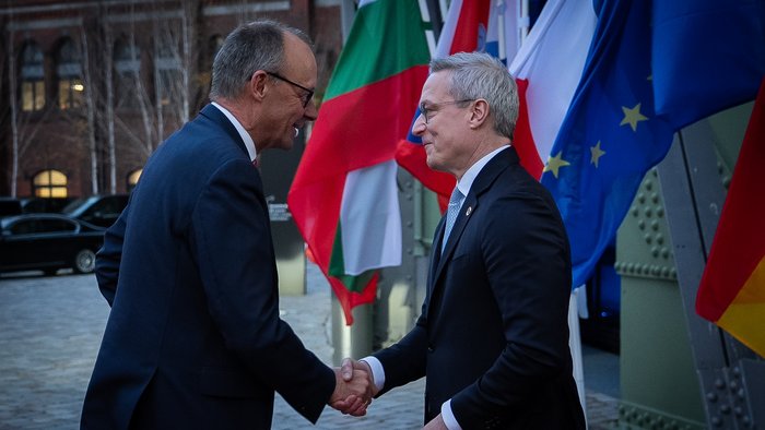 Digitalminister Karsten Wildberger gibt Bundeskanzer Friedrich Merz bei seiner Ankunft auf dem EUREF-Campus die Hand.