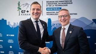 Evan Solomon und Karsten Wildberger schütteln sich die Hand.