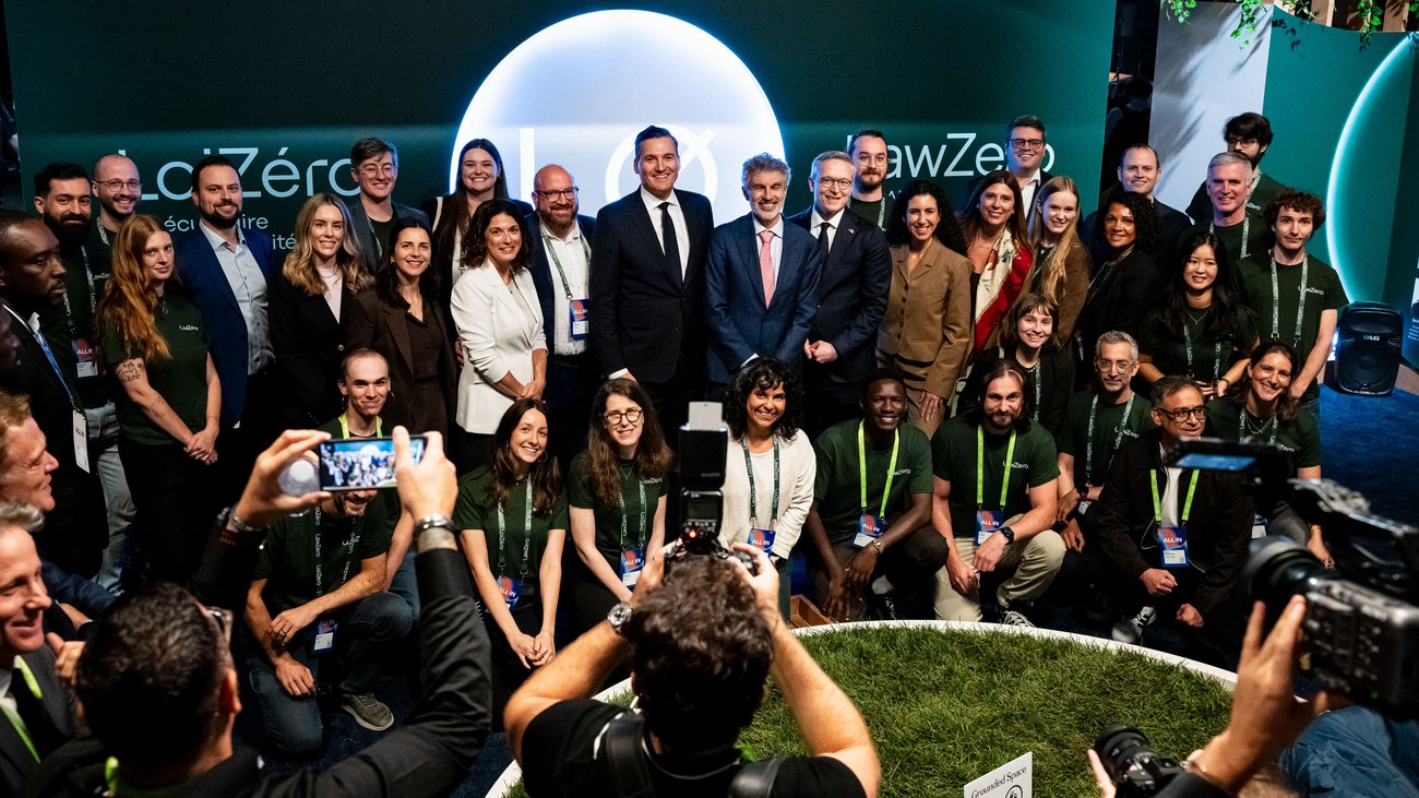 Gruppenfoto am Stand von LawZero. Im Vordergrund viele Fotografen. 
