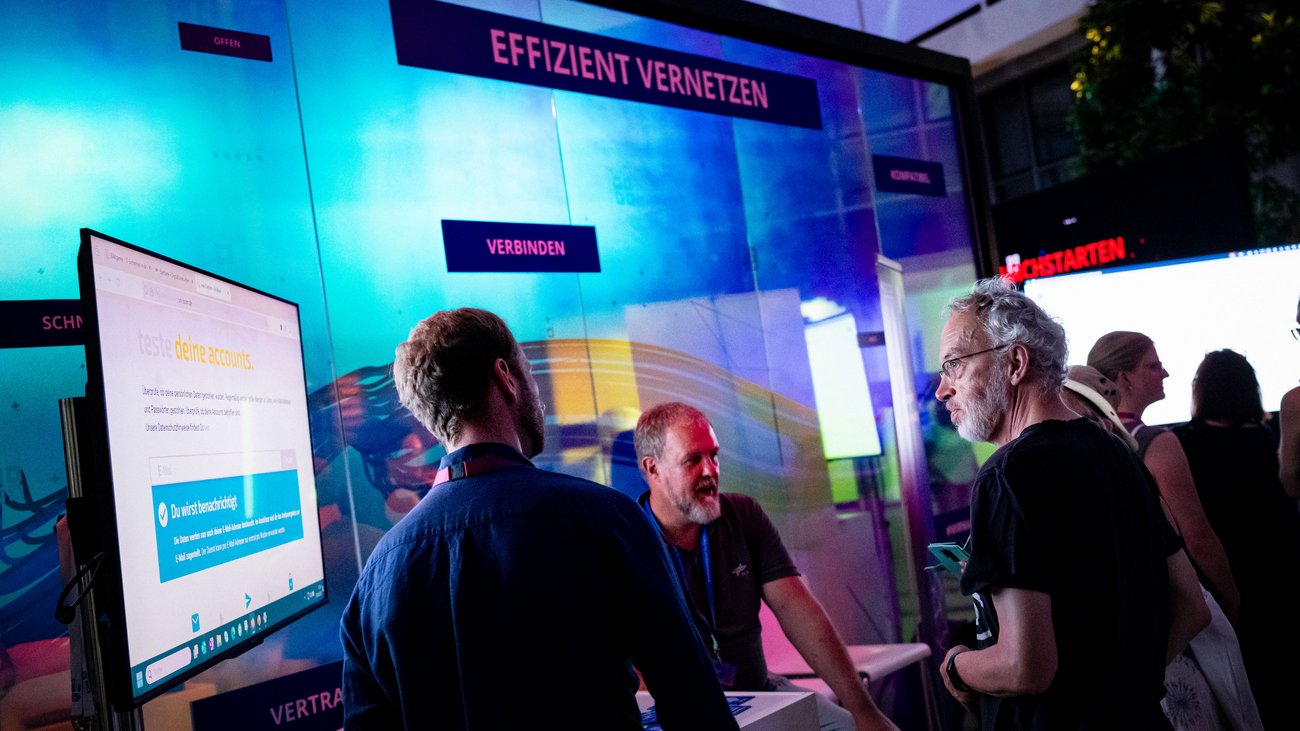 Mehrere Besucher und Fachexperten an einem Messestand