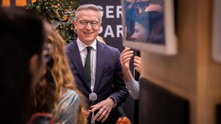 Karsten Wildberger hält ein Mikrofon in der Hand