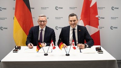 Wildberger und Solomon beim Unterschreiben der Vereinbarung.