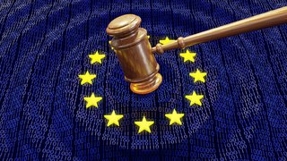 Ein Richterhammer schlägt in die Mitte einer EU-Flagge, deren blauer Hintergrund aus Einsen und Nullen besteht