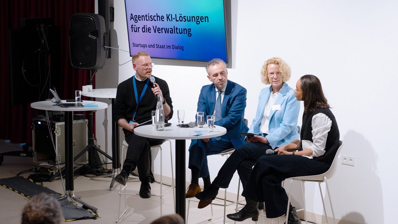 Ralf Junge-Pearl, Thomas Jarzombek, Dr. Uda Bastians und Judith Dada sitzen auf einer Bühne und diskutieren.