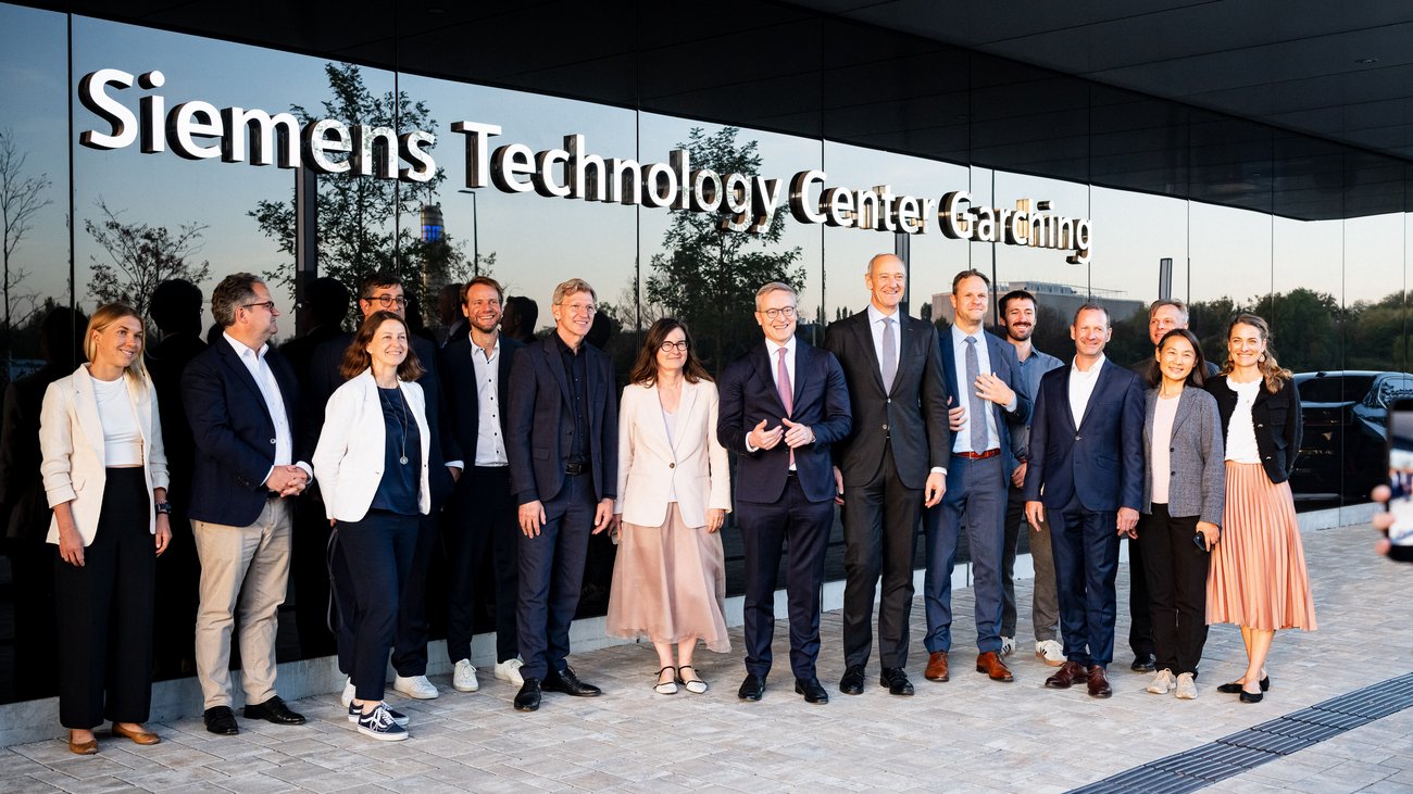 Karsten Wildberger und weitere Personen vor dem Siemens Technology Center Garching.