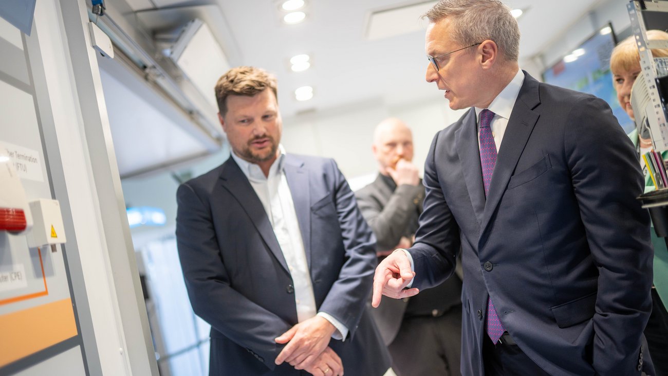 Bundesdigitalminister Dr. Karsten Wildberger und weitere Personen an einem Messestand der ANGA COM