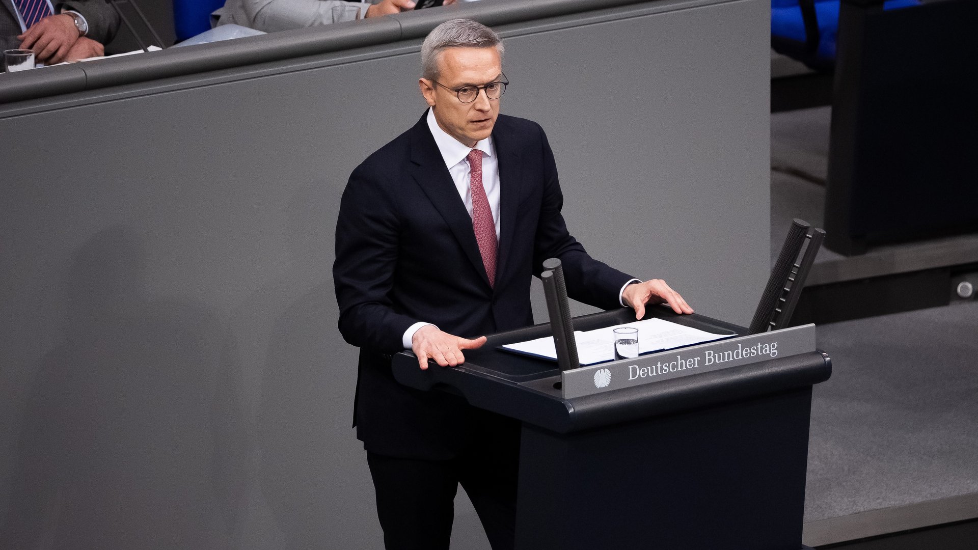 Dr. Karsten Wildberger steht im dunklen Anzug im Bundestag und hält eine Rede.