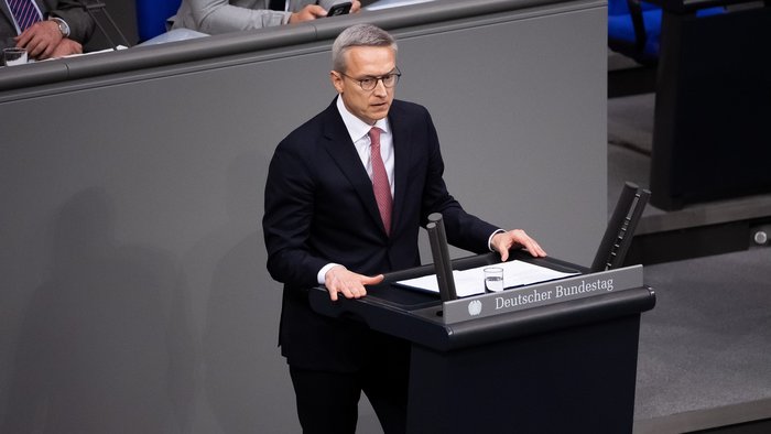 Dr. Karsten Wildberger steht im dunklen Anzug im Bundestag und hält eine Rede.