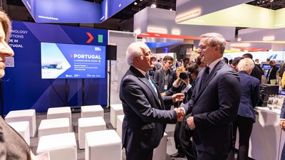 Begrüßungsszene am Messestand Portugals: Zwei Männer in Anzügen schütteln sich die Hände. 
