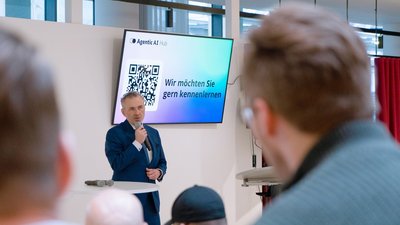Thomas Jarzombek steht auf der Bühne und begrüßt die Anwesenden.