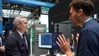 Dr. Karsten Wildberger ließ sich am Stand von Siemens zeigen, wie schnell man eine Roboteranlage neu programmieren kann. 