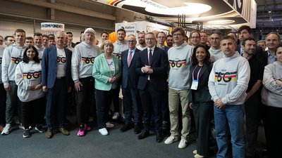Eine Gruppe von Menschen mit weißen Pullovern auf denen der Schriftzug "Team 6G Germany" steht, steht mit Minister Wildberger für ein Gruppenfoto bereit. 