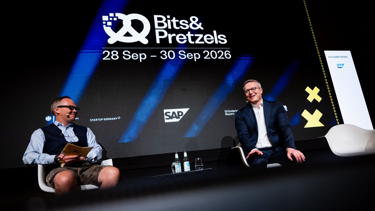 Karsten Wildberger und Bernd Storm sitzen nebeneinander auf einer Bühne.