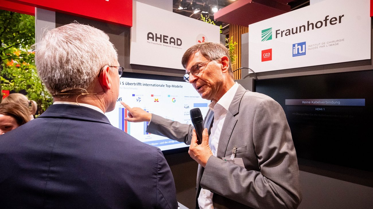 Ein Vertreter für Fraunhofer zeigt Digitalminister Wildberger einen Messestand.