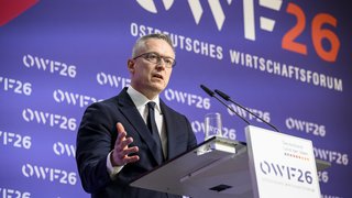 Karsten Wildberger steht an einem Rednerpult und spricht ins Mikrofon.